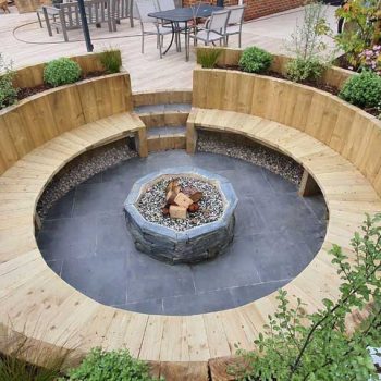 Wooden seating in a circle with a fire pit